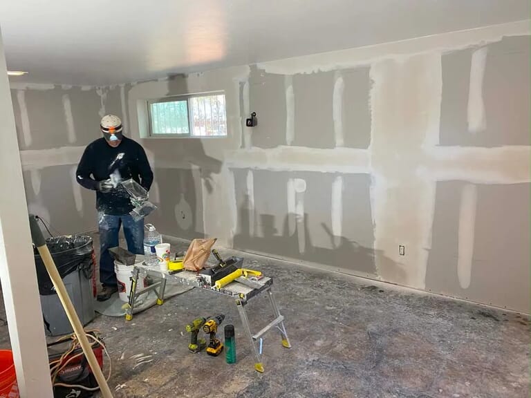 home remodeler painting floor, ceiling and working with hardwood